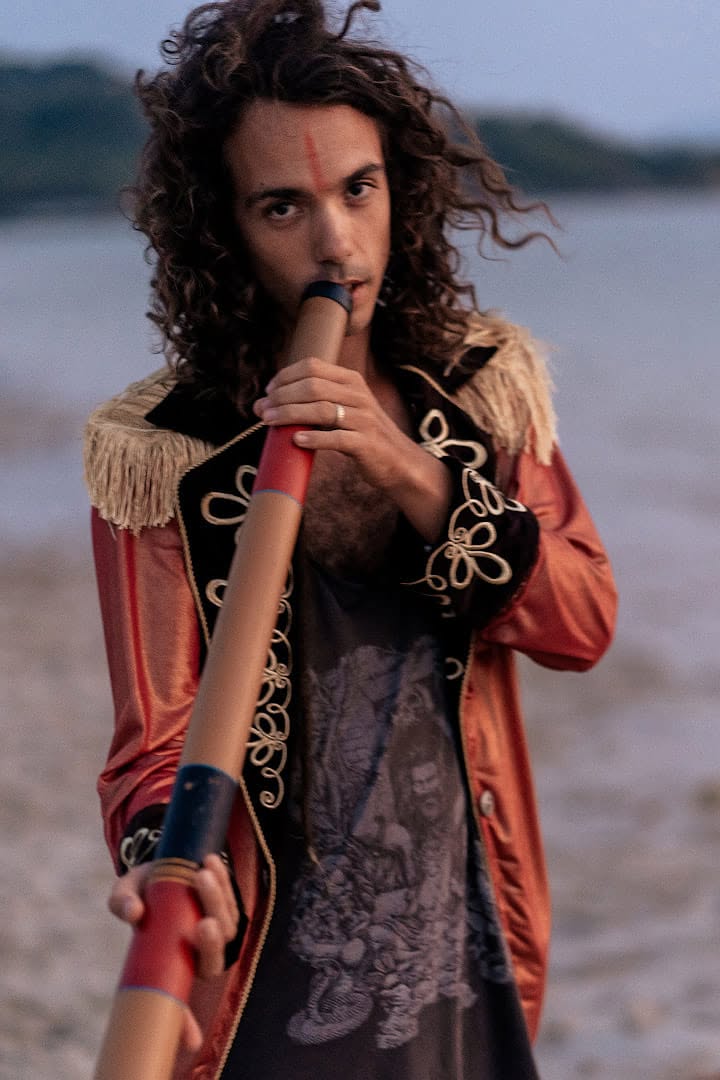 Oliv playing the didgeridoo by the sea