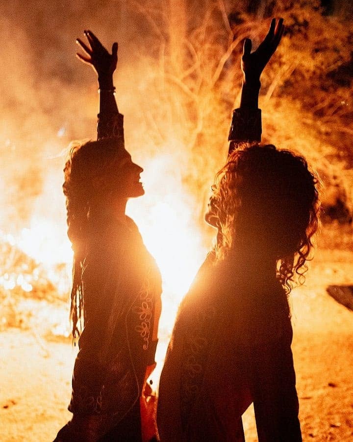 Oliv and Anna silhouetted against fire