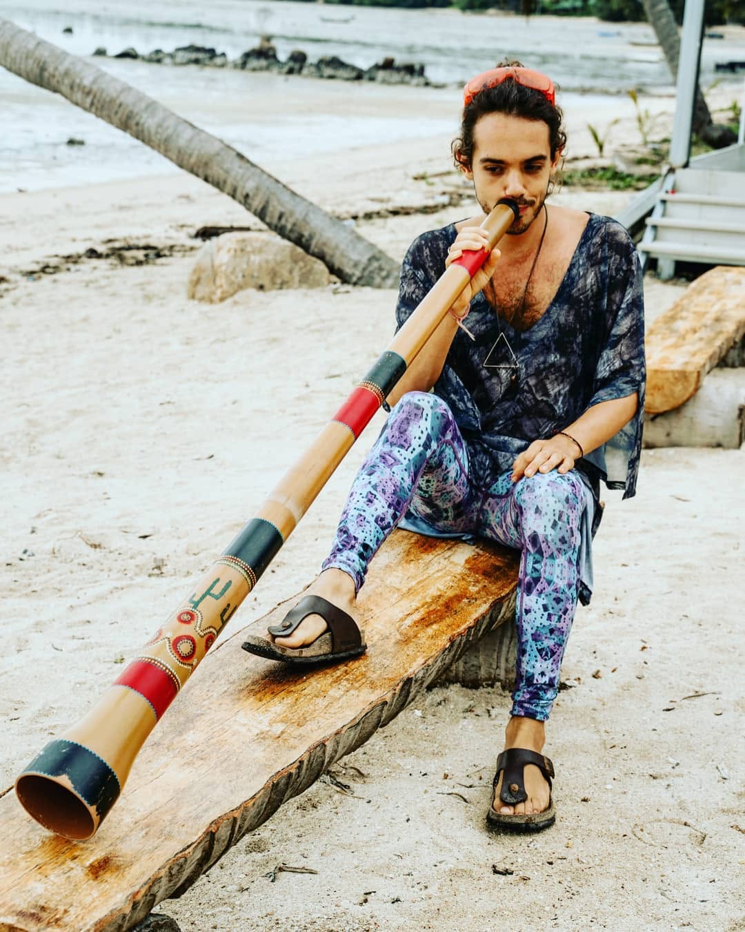 Oliv playing the didgeridoo by the sea on Koh Phangan